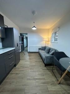 a living room with a couch and a kitchen at Modern 2 Bed Flat In Derby City in Derby