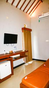 salon z telewizorem z płaskim ekranem na ścianie w obiekcie Ara Artati Lombok bungalows and Restaurant w mieście Selong Belanak