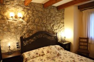 a bedroom with a stone wall with a bed at Paller Cal Cintet in Aristot