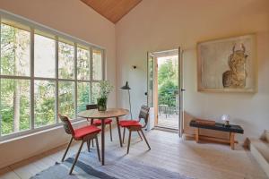 a living room with a table and chairs and a window at Urfeld26 Walchensee Berghaus mit Sauna in Urfeld