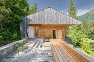 ein großes Holzgebäude mit einer Terrasse und Stühlen in der Unterkunft Urfeld26 Walchensee Berghaus mit Sauna in Urfeld