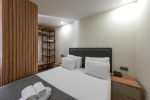 Schlafzimmer mit einem Bett mit weißer Bettwäsche und Kissen in der Unterkunft Verde Mare Hotels in Antalya