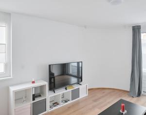 a living room with a tv on a white shelf at Wohnen in Wattens Top 3 in Wattens