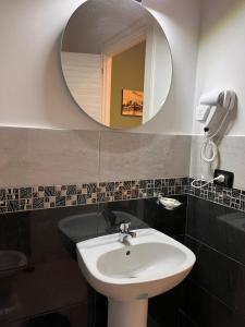 bagno con lavandino e specchio di Oceania Hotels Napoli a Napoli