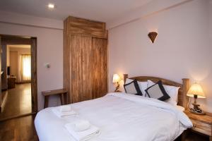 ein Schlafzimmer mit einem weißen Bett mit zwei Handtüchern darauf in der Unterkunft Hotel Timila in Pātan