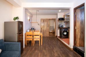 een keuken en eetkamer met een tafel en een koelkast bij Hotel Timila in Pātan