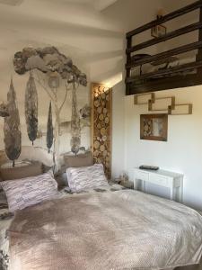 a bedroom with a bed with a tree mural on the wall at Hôtel La Pinède in Saint-Marcellin-lès-Vaison