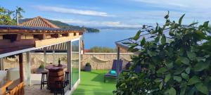 a patio with a view of the water at Luxury Sunrise Jacuzzi Apts, 50 m from the beach in Kali