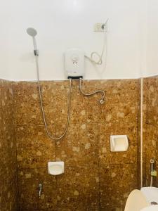 a bathroom with a shower and a toilet at Queen's Room Rental 4 in El Nido