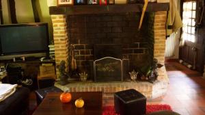 a living room with a brick fireplace with a tv at chaumière familiale weekend & vacances paisible in Saint-Philbert-sur-Risle