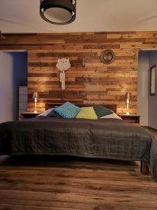 a bedroom with a wooden accent wall and a bed at Dalekie Niebo - przytulny dom wczasowy 