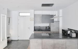 eine Küche mit weißen Wänden und einer grauen Arbeitsplatte in der Unterkunft Wohnen in Wattens Top 2 in Wattens