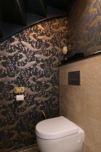 a bathroom with a toilet and a black and gold wallpaper at B&B Felix in Amsterdam