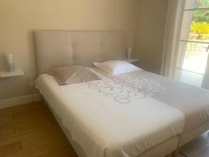 a large white bed in a room with a window at Mougins Mas lumineux vue sur le village in Mougins +28 photos