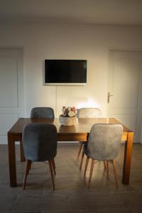 a dining room table with two chairs and a television at Apartmani ELEGANCE Tuzla in Tuzla