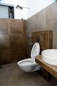 a bathroom with a white toilet and a sink at Krishna Dhwani Apartments in Tellicherry