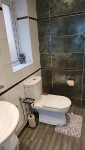 uma casa de banho com WC, 2 lavatórios e uma janela em Masters bedroom in a 3 bedroom house em Tettenhall