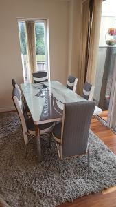 een eettafel en stoelen op een tapijt bij Masters bedroom in a 3 bedroom house in Tettenhall