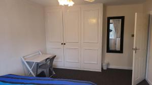 een slaapkamer met een bureau, een bed en een spiegel bij Masters bedroom in a 3 bedroom house in Tettenhall