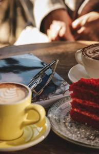 a table with two cups of coffee and a piece of cake at Limon Inn Hotel, Taşucu in Tasucu