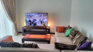 a living room with two couches and a tv at Cozy 2 BR Apartment with pool by Ceylon Vacation in Colombo