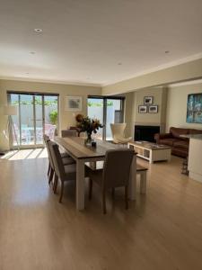 a living room with a dining room table and chairs at Luxury Townhouse in Stellenbosch CENTRAL (BACK-UP POWER) in Stellenbosch