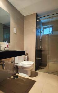 a bathroom with a toilet and a glass shower at Cozy 2 BR Apartment with pool by Ceylon Vacation in Colombo