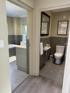 a bathroom with a toilet and a sink at Luxury Townhouse in Stellenbosch CENTRAL (BACK-UP POWER) in Stellenbosch