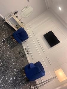 dwa niebieskie krzesła siedzące przed drzwiami w obiekcie Oceania Hotels Napoli w mieście Napoli