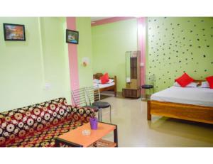 a living room with a bed and a couch at Hotel Poba, Jonai, Assam 