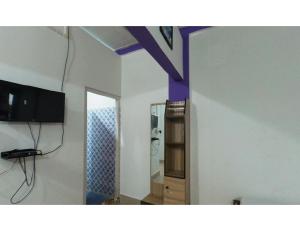 salon z telewizorem i lustrem w obiekcie Hotel Poba, Jonai, Assam 