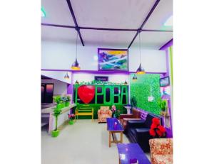 ein Wohnzimmer mit lila und grünen Möbeln in der Unterkunft Hotel Poba, Jonai, Assam 