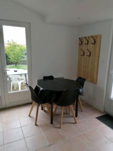 jadalnia z czarnym stołem i krzesłami w obiekcie Maison 3 personnes dans village atypique w mieście Talmont-sur-Gironde +4 zdjęcia