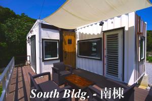 uma pequena casa com um alpendre e um pátio em Vacation Village Okinawa - Yambaru em Nakijin