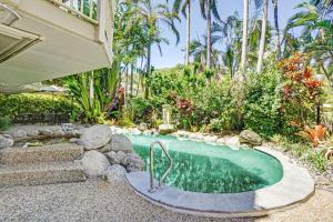 a small swimming pool in a garden with trees at Driftwood Mantaray in Port Douglas