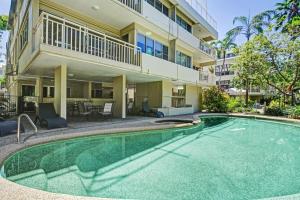a swimming pool in front of a building at Driftwood Mantaray in Port Douglas