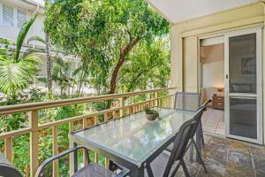 a patio with a table and chairs on a balcony at Cozie Homes - Mantaray on Macrossan in Port Douglas