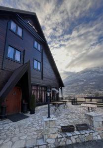 a large wooden building with a bench and a table at Camp Hotel Lake Views in Plav