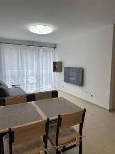 a dining room with a table and a tv at Appartement - Tournan en Brie a 20min de Disneyland in Tournan-en-Brie