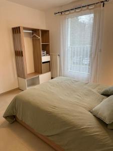 a bedroom with a large bed and a window at Appartement - Tournan en Brie a 20min de Disneyland in Tournan-en-Brie