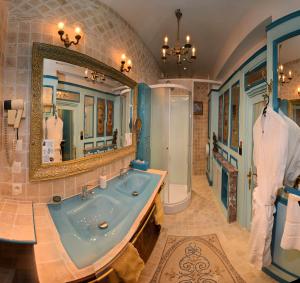 een badkamer met een bad en een grote spiegel bij La Maison de l'Argentier du Roy in Loches