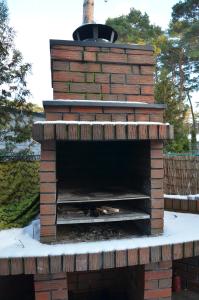 an outdoor brick oven with snow on the ground at Marina Boszkowo in Boszkowo-Letnisko +23 photos