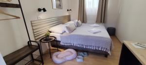 een kleine slaapkamer met een bed met witte kussens bij Budapest Csaszar Hotel in Boedapest