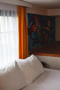 a bed with a white pillow in front of a window at Limon Inn Hotel, Taşucu in Tasucu