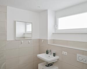 Baño blanco con lavabo y espejo en Wohnen in Wattens Top 5, en Wattens