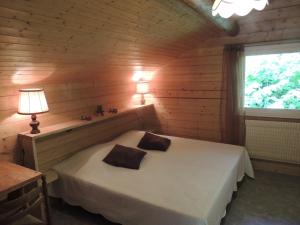 Un dormitorio con una cama en una cabaña de madera. en Lou R'bat Pays, en Le Grand-Bornand