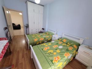 1 dormitorio con 2 camas y espejo en Elbasan modern apartment city center, en Elbasan