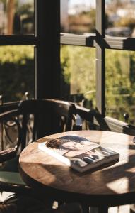 a wooden table with a picture on it in front of a window at Limon Inn Hotel, Taşucu in Tasucu