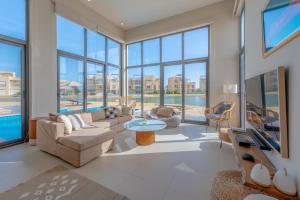 una sala de estar con muchas ventanas en Long Island Gouna 5BR Tawila Beach House & Pool en Hurghada