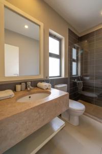 La salle de bains est pourvue d'un lavabo, de toilettes et d'un miroir. dans l'établissement Long Island Gouna 5BR Tawila Beach House & Pool, à Hurghada